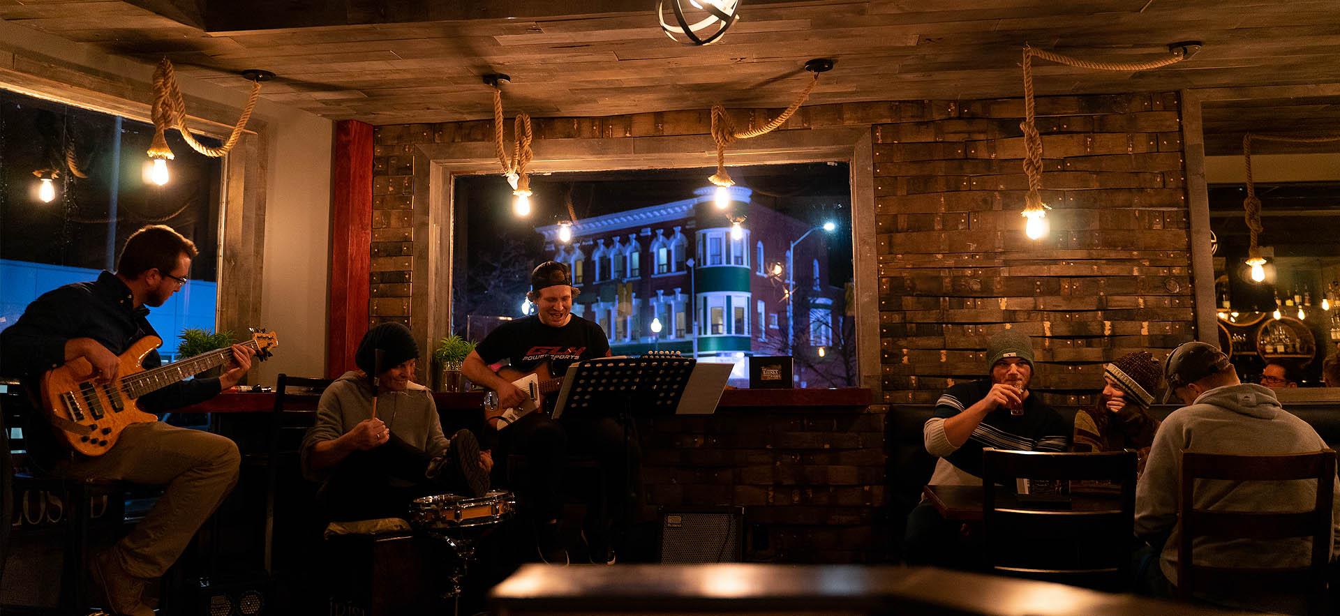 Musicians and viewers in a bar at night