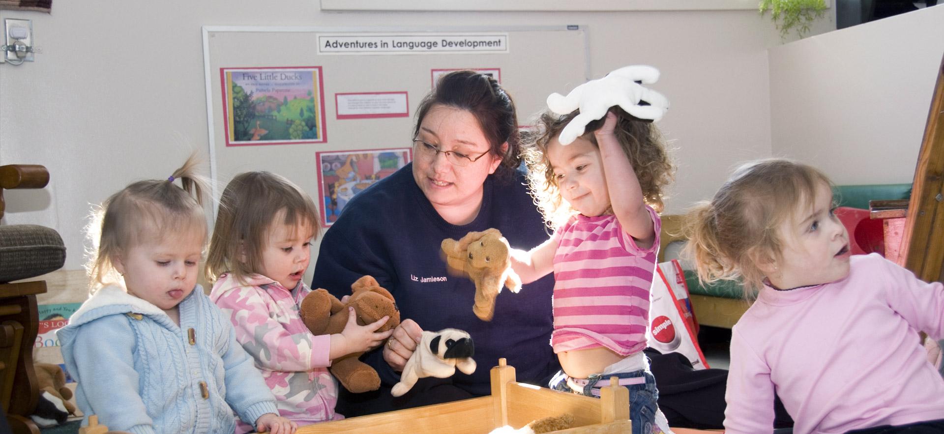 One female Early Childhood Education student plays with young children.
